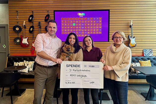 4 Personen halten einen Spendenscheck