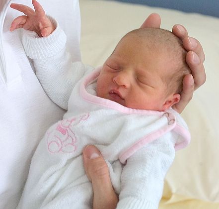 Baby in der Hand geborgen